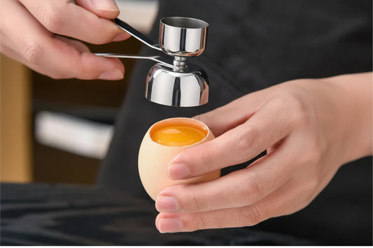 Metallic egg separator being used to separate an egg yolk from the white.